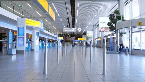 Amsterdam, Netherlands, April 2020.  Quiet departure hall at Schiphol airport during corona crisis. Gimbal walking shot.