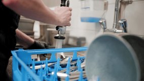 Close up shot of male hands washing and cleaning dishes in restaurant kitchen - Powered by Shutterstock - Get 15% off with code: PIKWIZARD15