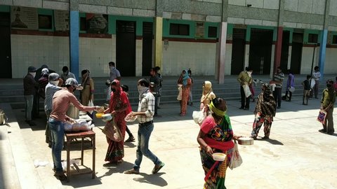 Delhi, Delhi / India - April, 20, 2020 : Food being distributed to underprivileged society at Government School during covid19 lockdown maintaining social distancing, Delhi, India