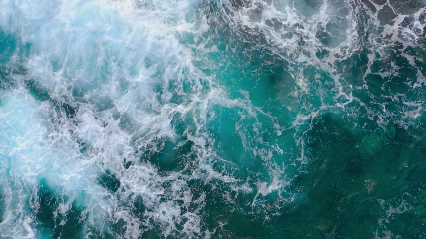 Top view of the ocean surface near the rocky coast off the island of Tenenife, Canary Islands, Spain. Aerial drone footage of sea waves reaching shore | Shutterstock HD Video #1050816061