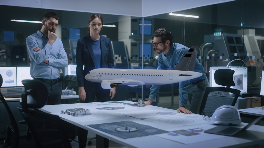 Aeronautics Factory Office Meeting Room: Team of Diverse Engineers and Managers Work on an Augmented Reality Airplane Jet Engine Simulation. Modern Industry 4.0 Research and Development Test. Royalty-Free Stock Footage #1050816415