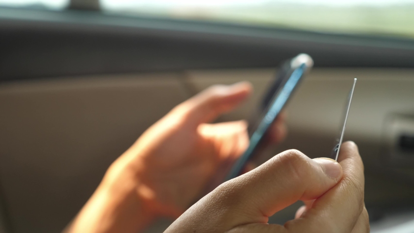 Hands holding plastic credit card and using mobile phone. Online shopping concept.