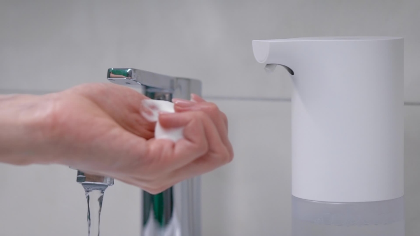 Automatic foam generator puts on hand the desired dose of soap. Women's hands require care and hygiene. | Shutterstock HD Video #1050821617