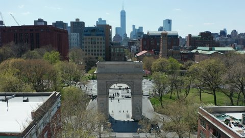 sunny day flying over arch and tilting down on Washington Square Park in NYC