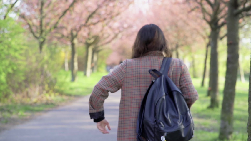 Japanese geisha girl in traditional kimono walking alone among blooming ...