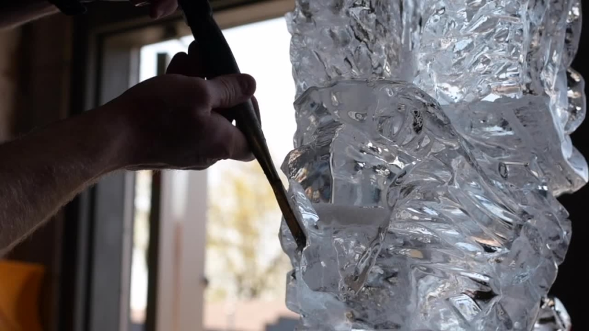 Closeup of ice sculptor cutting/shaping eagle head ice sculpture with chisel Royalty-Free Stock Footage #1050838630