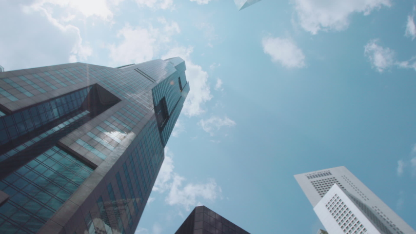 Pan looking up at skyscrapers in the Raffles Place district of Singapore