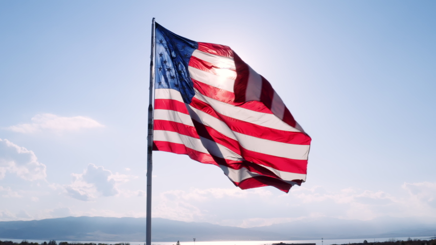 Aerial of massive American Flag slowly flapping in breeze in slow motion Royalty-Free Stock Footage #1050853189