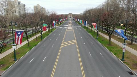 Flags line empty Ben Franklin Parkway during Philadelphia Covid quarantine shutdown shelter in place, coronavirus stay at home order, aerial drone footage