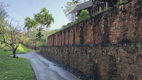 Krabi, Thailand - February 8 2018: Brick stone walls with water flowing through the lush gardens of luxury hotel Phulay Bay, a Ritz Carlton Reserve resort