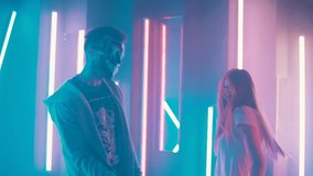 a guy with his girlfriend dancing and having fun in a neon room to the music