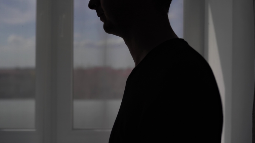 Silhouette of a coughing man on a window background. The patient is treated at home for the virus Covid-19 Royalty-Free Stock Footage #1050872509