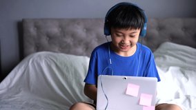 A boy wearing headphone for play game at home.  