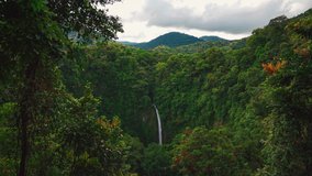 A beautiful Cinemagraph / seamless loop of the Arenal Waterfall at La Fortuna in the Jungle, surrounded by huge trees and volcanos.