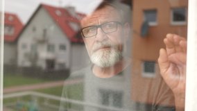 Husband and wife outside the window of their house. The street and houses are reflected in the glass. A man hugs a woman. Family of elderly during quarantine coronovirus covid-19 - Powered by Shutterstock - Get 15% off with code: PIKWIZARD15