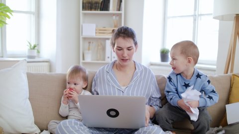 Stressed mother with small children working in home office, quarantine concept.