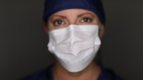 Female Doctor or Nurse Moving Into Focus Then Putting On Medical Face Mask.