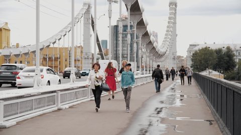 Moscow, Russia - Jule 10, 2019: people walk in slow motion on the Krymsky Bridge or Crimean Bridge is a steel suspension bridge in Moscow, Russia