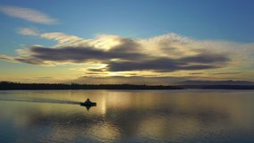 Aerial Drone Video of a Small Ferryboat Crossing Hales Pass at Sunrise. On a calm beautiful morning a small ferryboat makes it's way from the mainland to Lummi island in the Pacific Northwest.