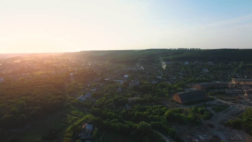 Lost village in the valley. Houses wrapped in dense greenery, drowning in the rays of the sun. Old factory