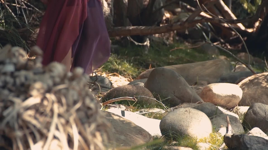 Mysterious woman walking and washing hands in a river into the jungle