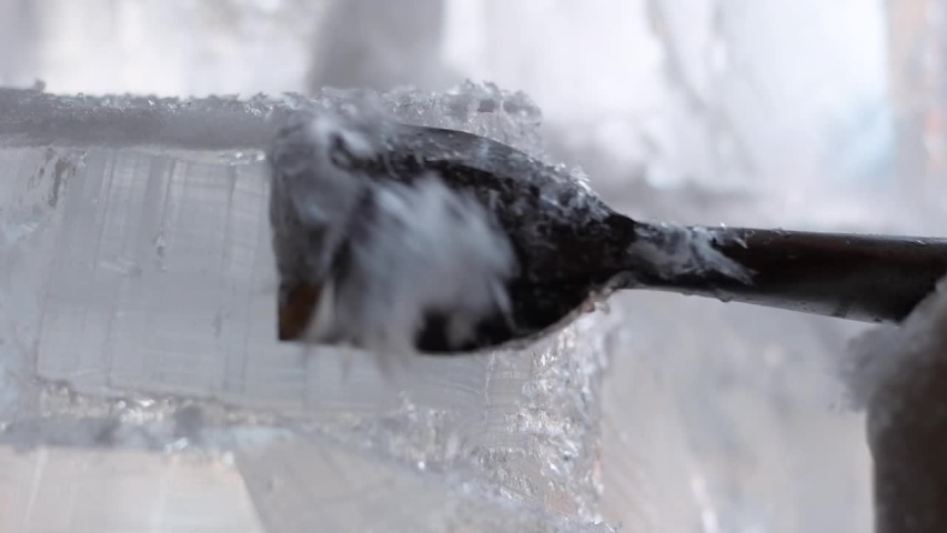 Closeup of ice sculptor shaving ice sculpture with chisel Royalty-Free Stock Footage #1050922198