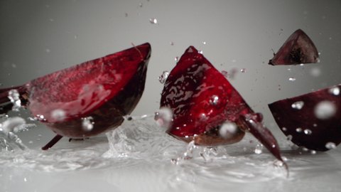 Cut beet falling on water surface. Shot with high speed camera, phantom flex 4K. Slow Motion.