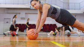 Young african american woman doing push ups with basketball and then laughing and falling down on court after workout - Powered by Shutterstock - Get 15% off with code: PIKWIZARD15