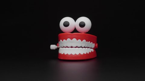 Toy teeth. Сhattering teeth toy moving on black background.