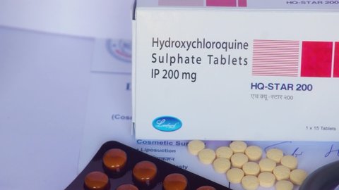 Jaipur, India, Circa 2020 - Video panning left to right on a box of hydroxycholorquine on a white background with a stethoscope a other medicines on its side