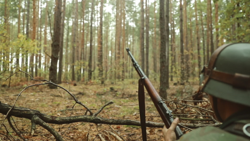 Historical Re-enactment. Re-enactor Dressed Like German Wehrmacht Infantry Soldier In World War II Shooting Rifle from Forest entrenchment. slow mo, slow motion, motion, slow, slo-mo, slow-mo.