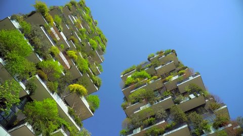 Milan, Italy, April 22, 2020: modern and ecological skyscrapers with many trees on each balcony. Bosco Verticale. Modern architecture, vertical gardens, terraces with plants. Green Planet. Blue sky