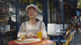 Smiling girl having breakfast in the outdoor cafe, Paris