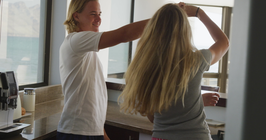 Caucasian couple at home, dancing and embracing in the sitting room. Social distancing and self isolation in quarantine lockdown.