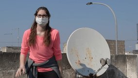 Girl wearing in protective medical mask, coronavirus walk on the roof of her home during quarantine of coronavirus, slow motion