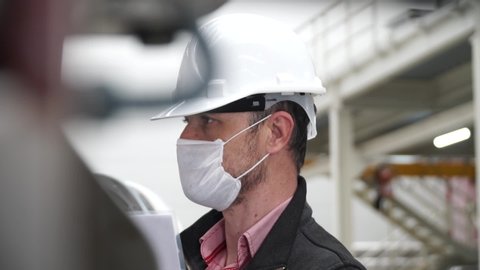 worker/engineer wearing disposal face mask for protect dust smoke and corona virus while working in workplace or factory.