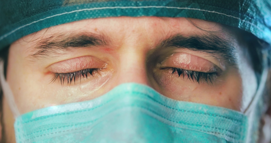 Eyes of a doctor or nurse as she cries after a grueling shift to treating Coronavirus patients in the intensive care unit. Royalty-Free Stock Footage #1050996703
