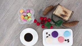 Coffee cup with candies and cookies on wooden table background.