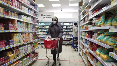 Moscow / Russia - 04 23 2020: People walk with protective medical face masks in the store. Half-empty supermarket in the afternoon during the quarantine period in Moscow. COVID-19