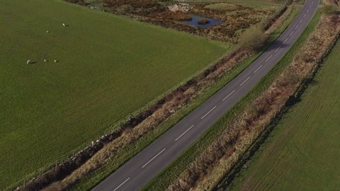 Drone footage of a person mountain biking along an empty country road on a sunny morning in North Yorkshire England completely isolated