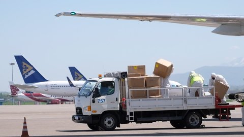
Almaty / Kazakhstan - 04.23.2020 : Airport employees unload humanitarian cargo from the plane