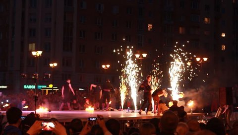 NOVOSIBIRSK, RUSSIA - MAY 23: Street performer dance with burning fans at evening fireshow, on May 23, 2015, Novosibirsk, Russia.