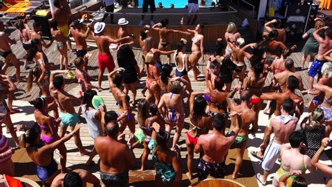 Mykonos, Greece - 08.22.2019: crowd of passengers dancing during a pool party on board a cruise ship