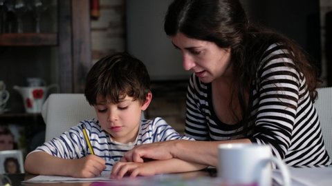 Mother and son doing homework at home living room, correcting with rubber