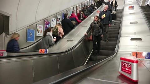 London Underground, UK - January 2020: Escalators moving up and down staircase. Crowd of people moving on it. Downtown.