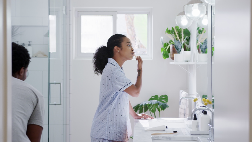 Man surprising woman wearing pyjamas brushing teeth standing at sink in bathroom - shot in slow motion | Shutterstock HD Video #1051072354