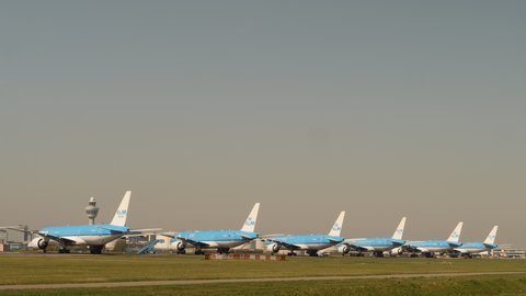 Amsterdam, Netherlands, April 2020. Parked airplanes lined up at Schiphol airport during corona crisis.