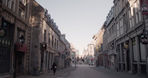 MONTREAL, QUEBEC - MARCH 27, 2020: A few random people walk the streets in historic Montreal city empty and barren during quarantine due to coronavirus pandemic 