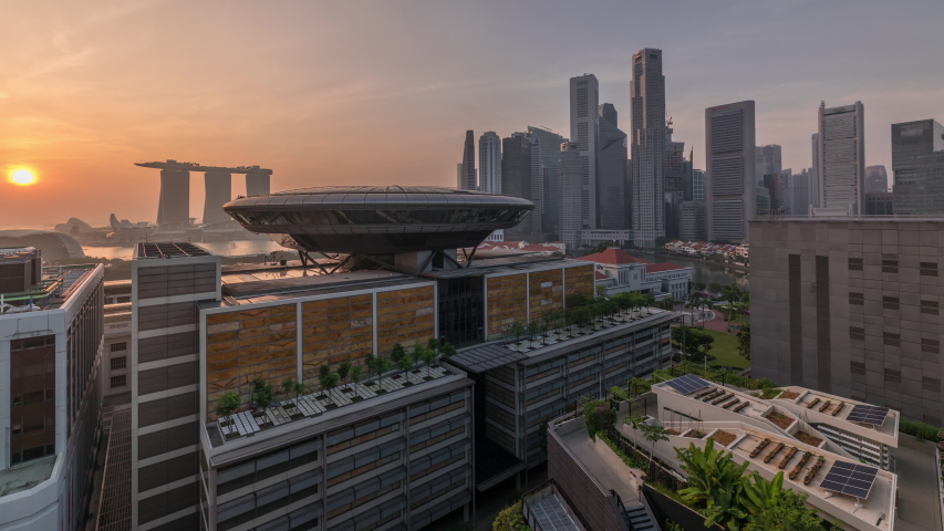 Sunrise over Colorful of Singapore Central business district aerial timelapse hyperlapse cityscape skyline at Marina Bay with Singapore Academy of Law and Parliament House from above.