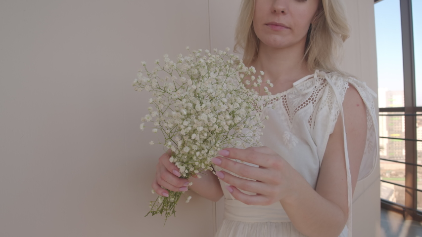 Young woman flowers in bloom. Holding a beautiful white bouquet.